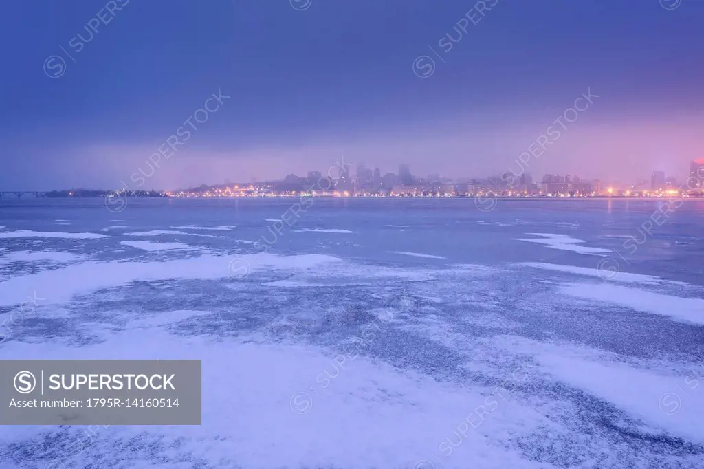 Ukraine, Dnepropetrovsk region, Dnepropetrovsk city, Dramatic sky over frozen river at dusk