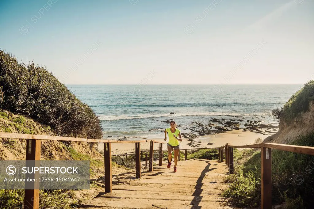 USA, California, Newport Beach, Woman running up stairs