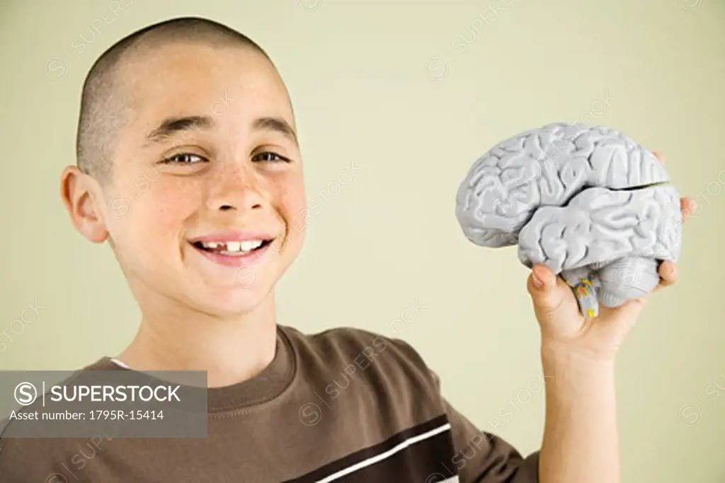 Boy holding human brain model