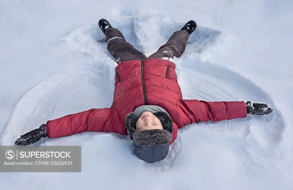 Boy making snow angel