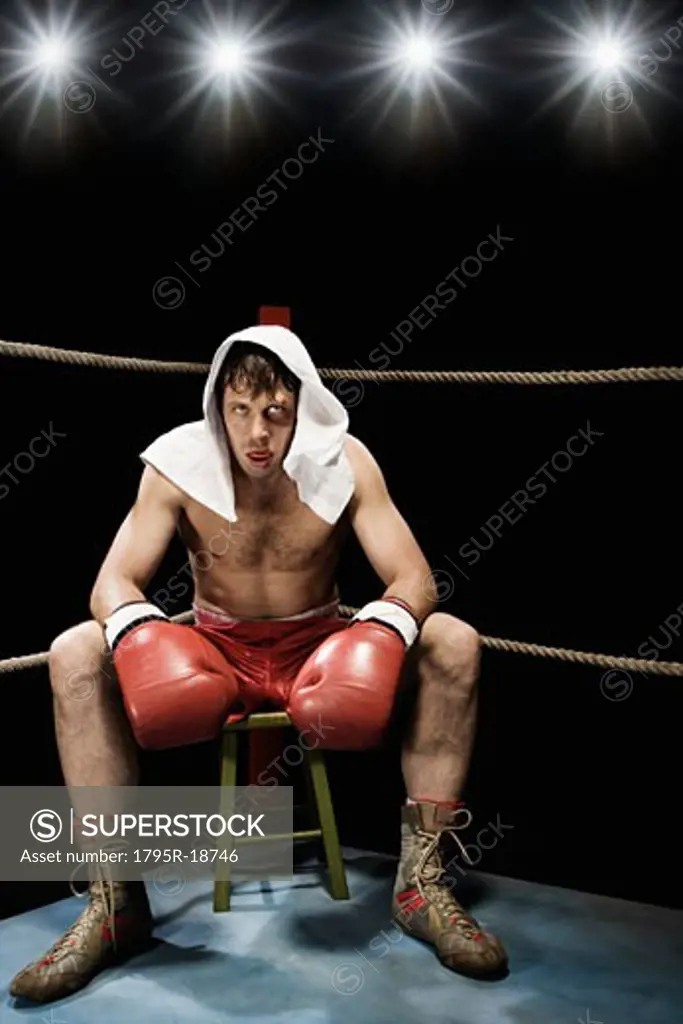 Boxer sitting on stool in corner of boxing ring