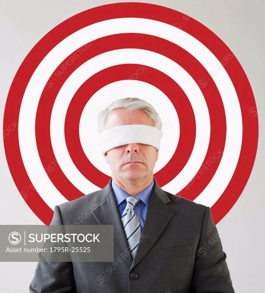 Blindfolded man standing in front of bull´s eye