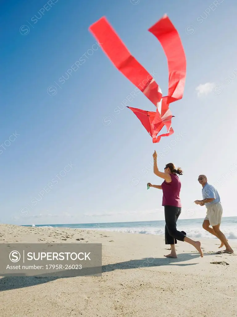 Couple flying kite on beach