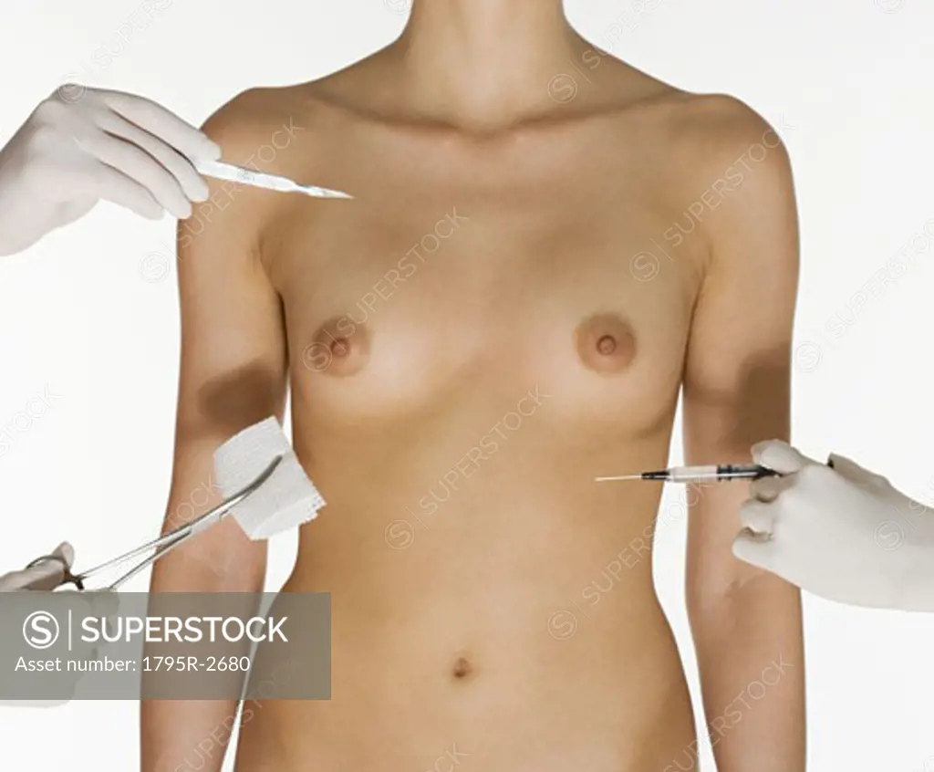 Nude female torso with medical instruments - SuperStock