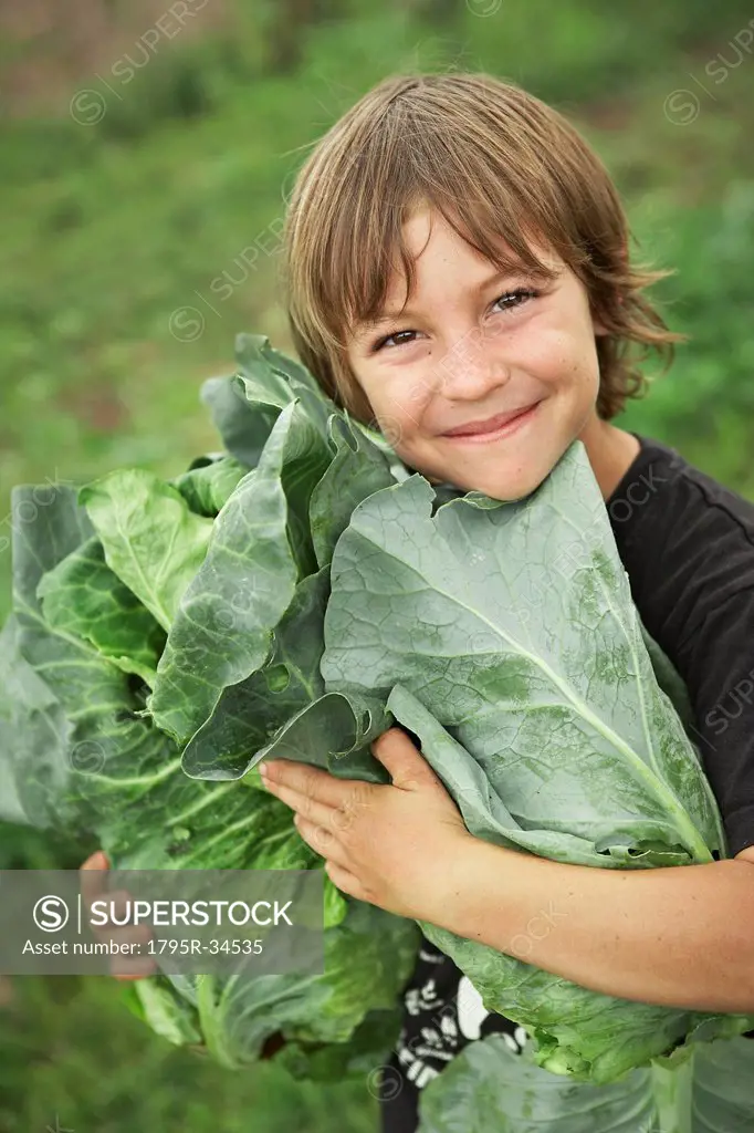 Portrait of boy 6_7 holding lettuces