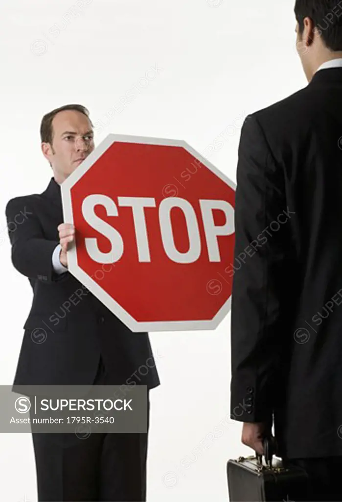 Man holding stop sign in front of another man