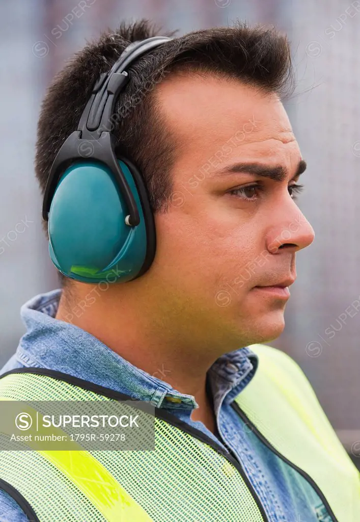 Construction worker wearing reflective clothing and headphones