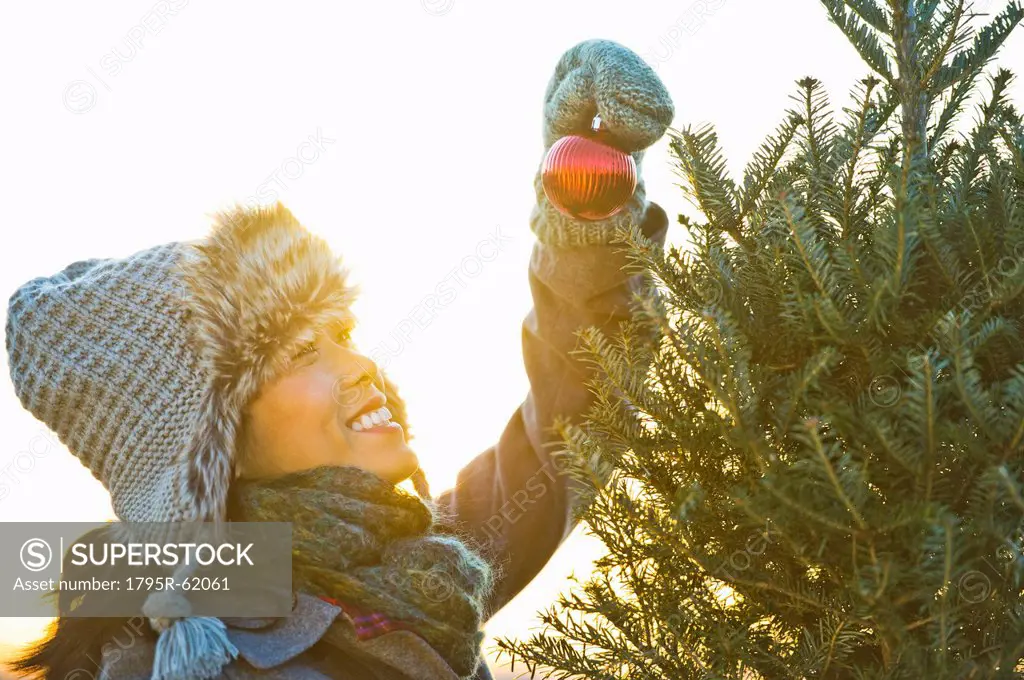 Smiling woman decorating Christmas tree