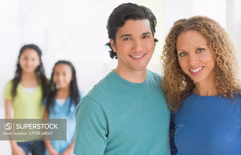 Portrait of parents with daughters 10_13 in background