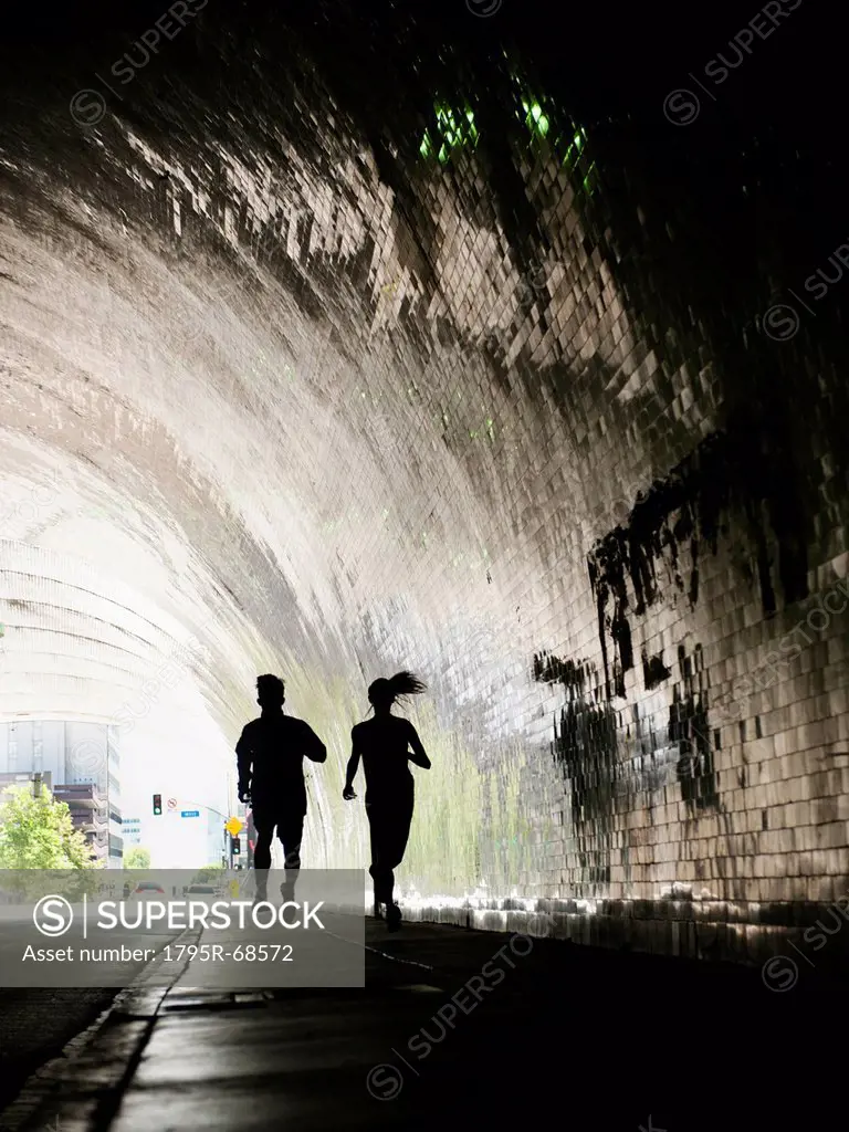USA, California, Los Angeles, Man and woman running in tunnel