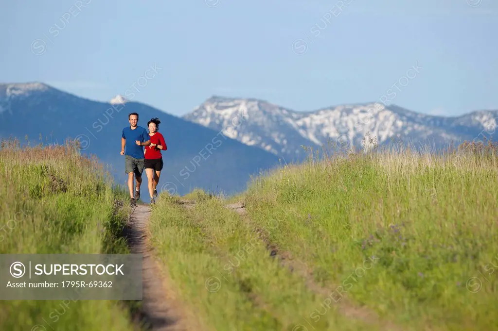 USA, Montana, Kalispell, Couple jogging in mountainside