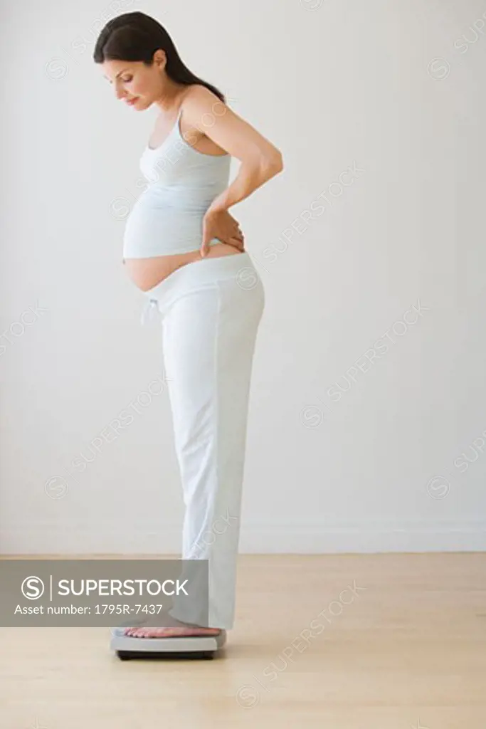 Pregnant woman standing on scale