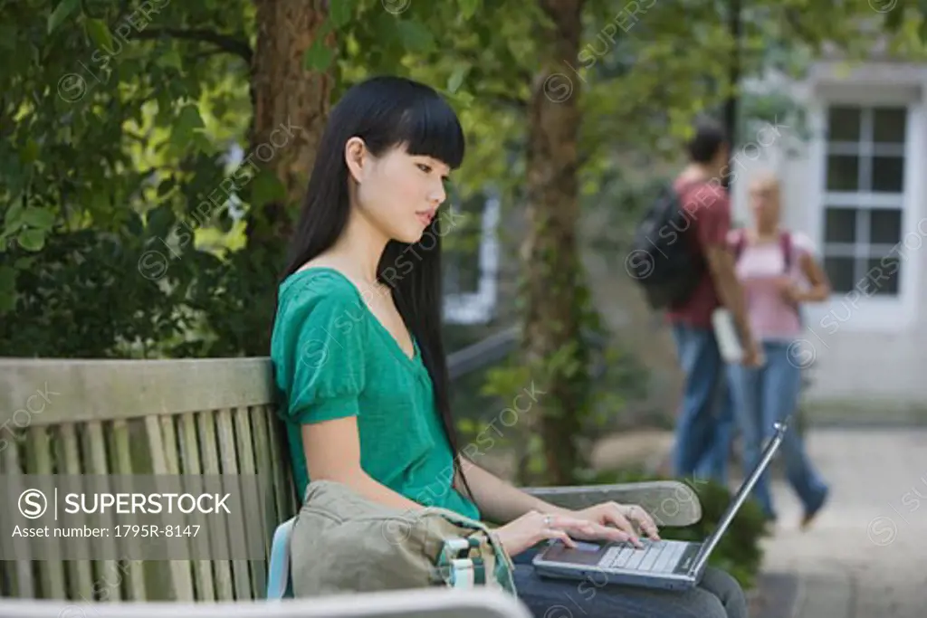 Female college student typing on laptop