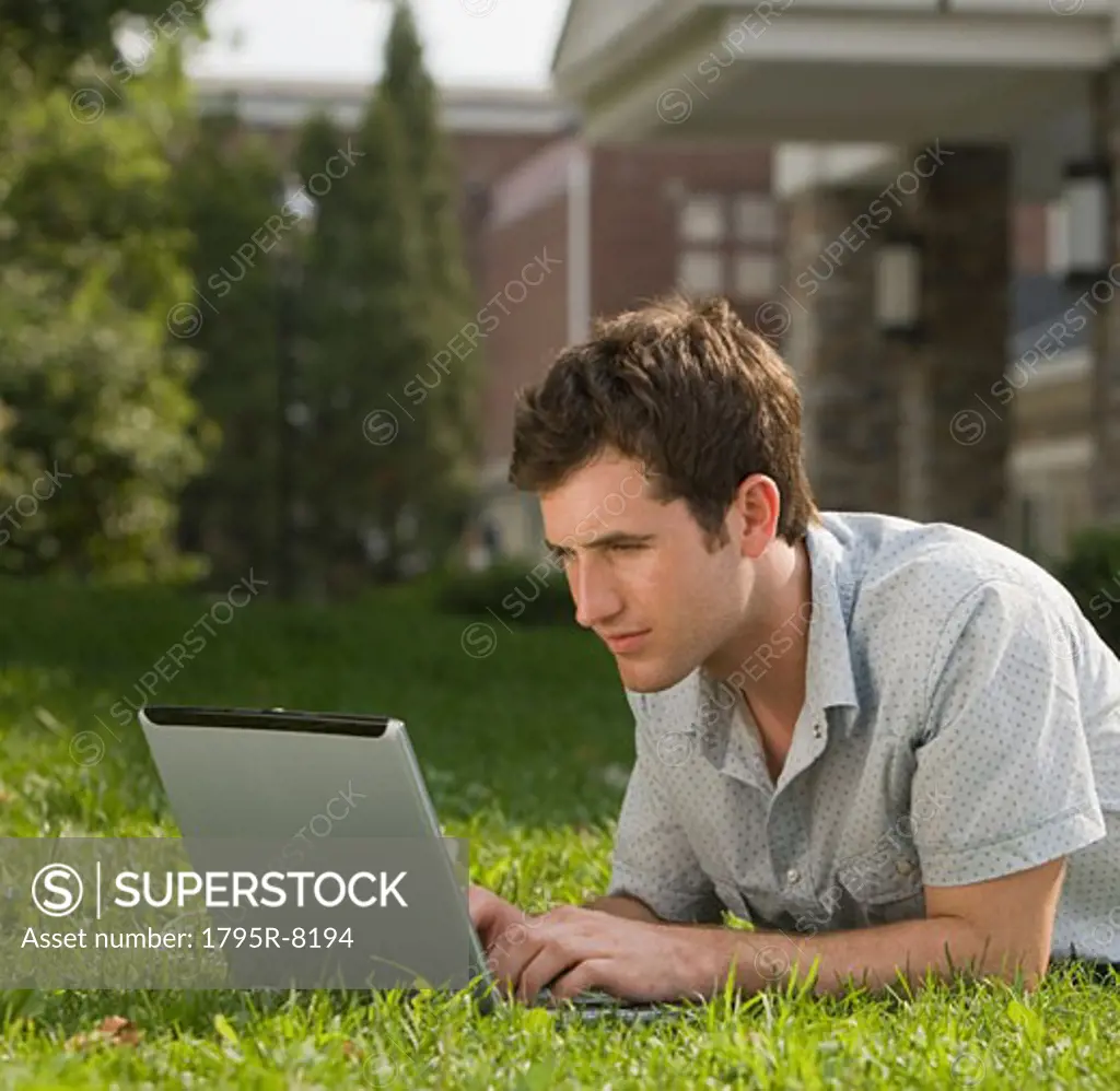 Male college student typing on laptop