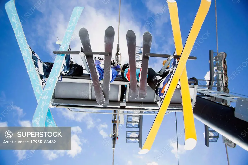 Family of skiers on ski lift seen from below