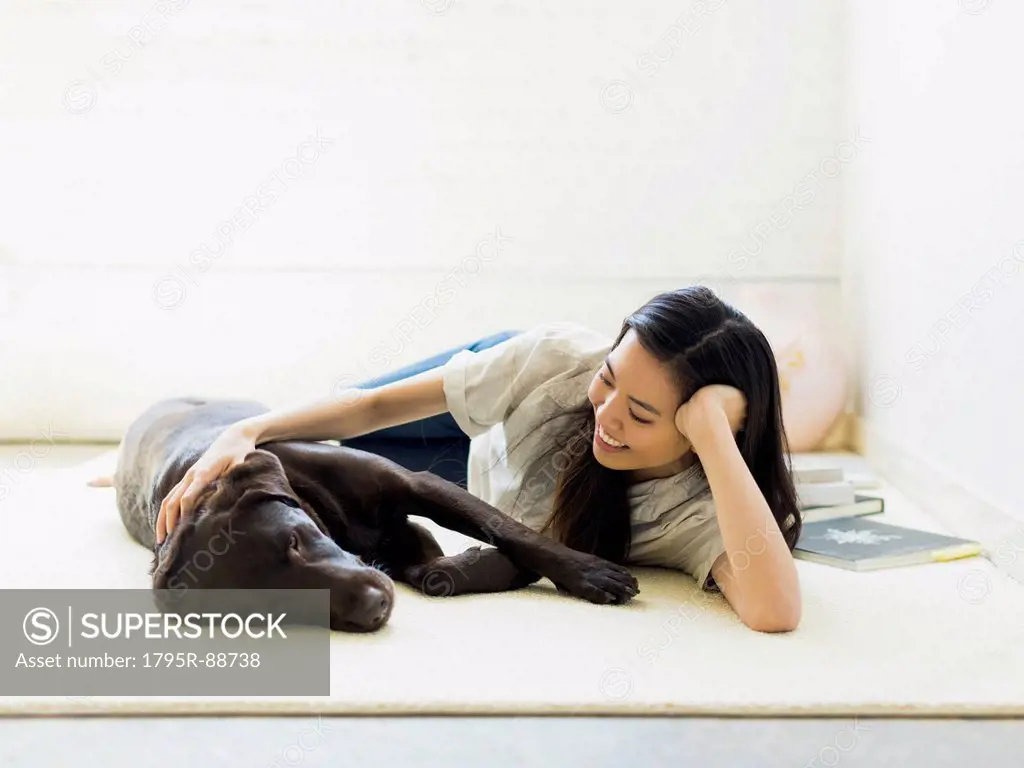 Woman with dog lying on floor