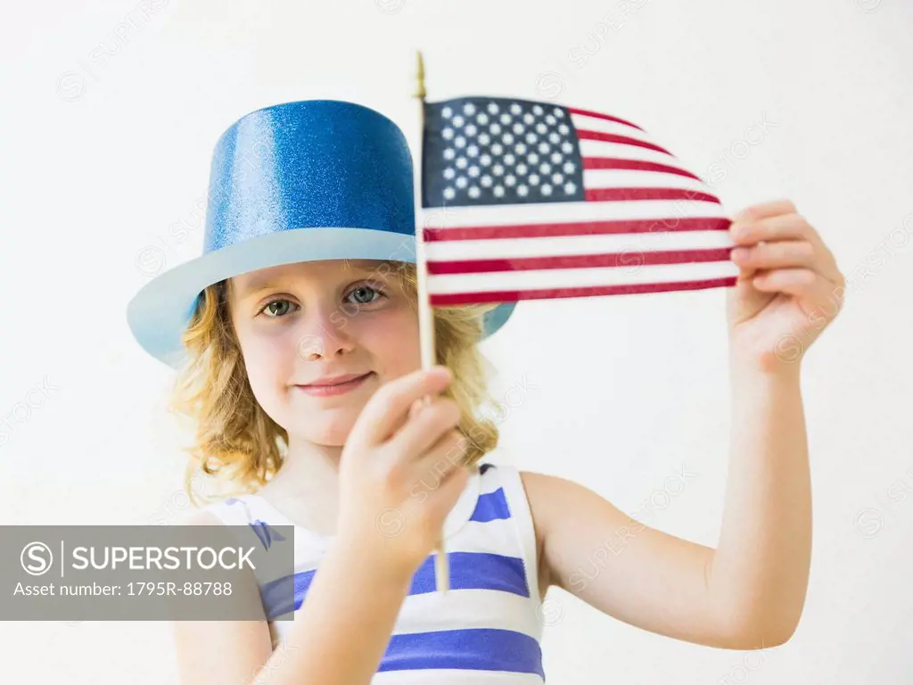 Portrait of blonde girl (4-5) holding American flag