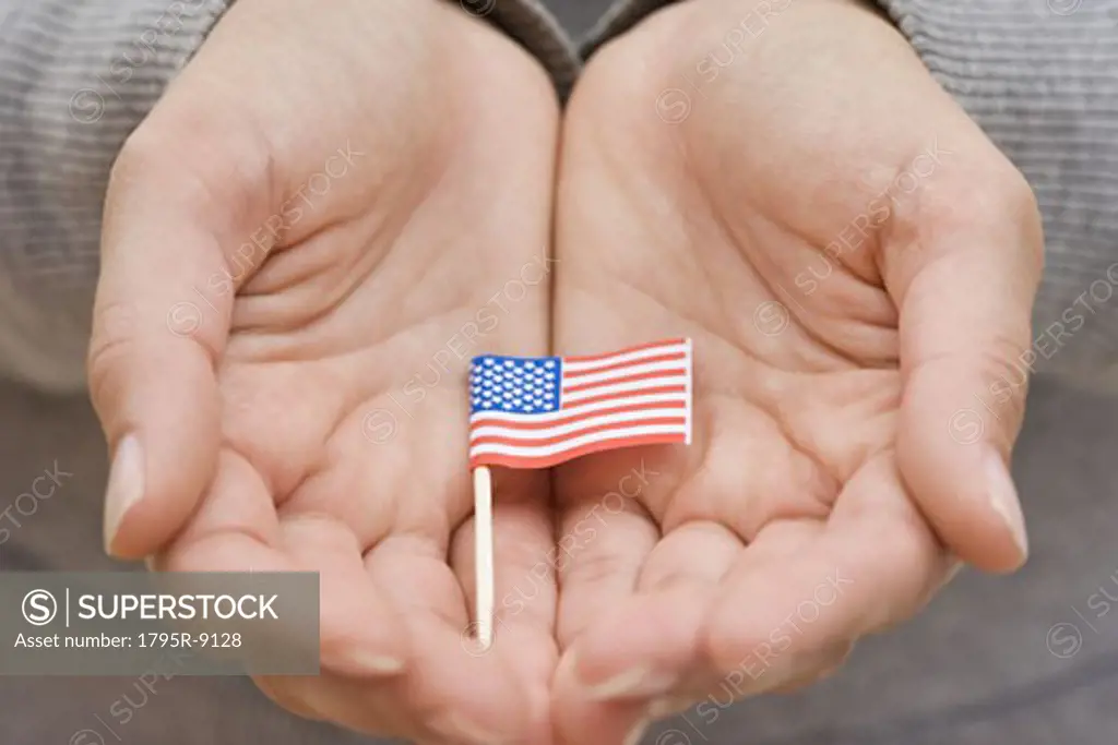 Hands holding small US flag