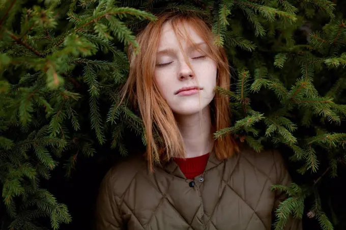 Portrait of young woman in foliage