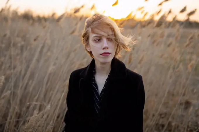 Russia, Omsk, Portrait of young woman in tall grass