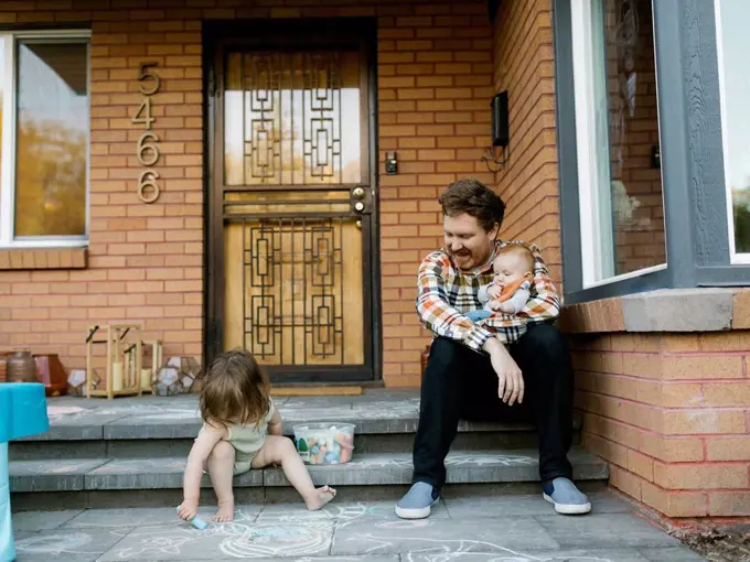 Father with kids sitting on porch