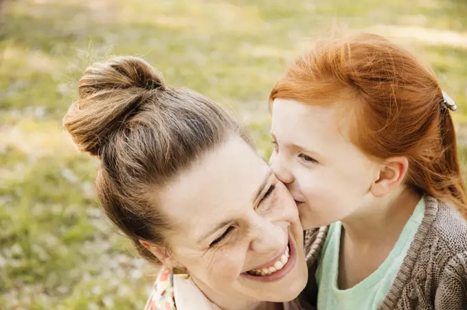 Portrait of smiling mid adult mother and daughter in park