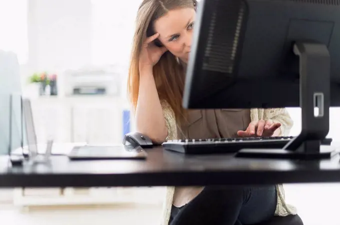 Portrait of young woman working on computer in office