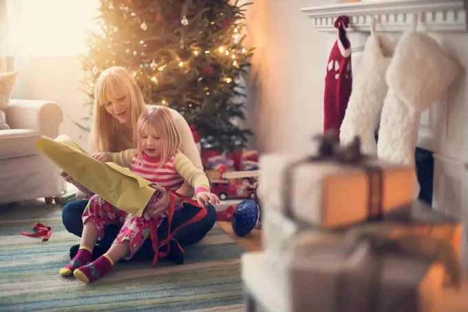 Mother and daughter (4-5) opening christmas presents