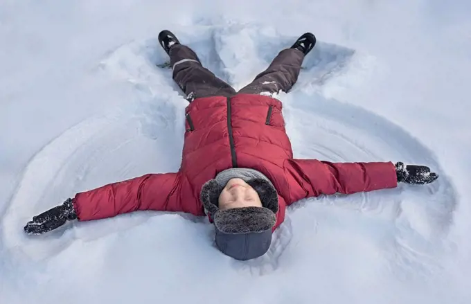 Boy making snow angel