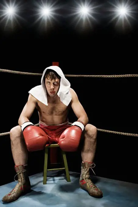 Boxer sitting on stool in corner of boxing ring