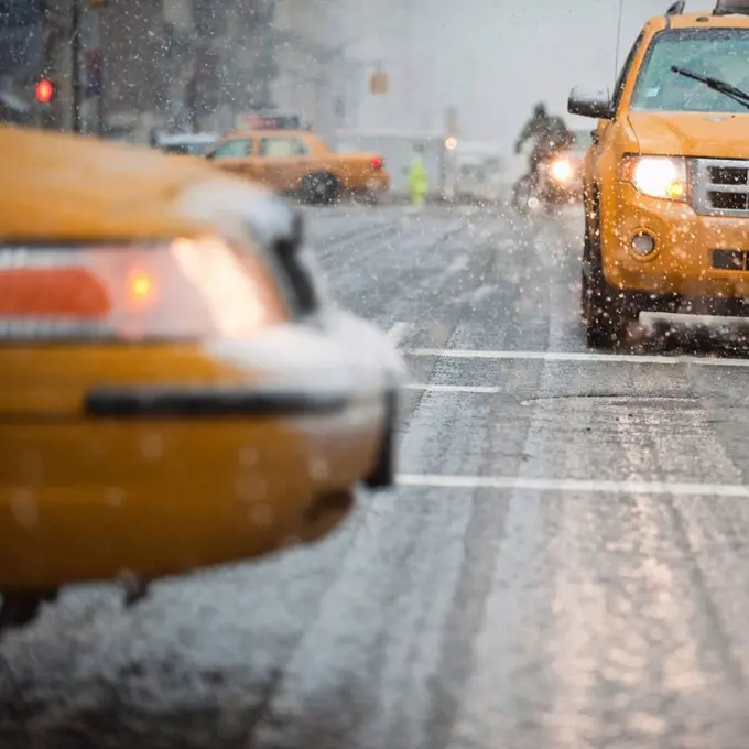 USA, New York, New York City, Close_up of yellow cab on street in snow