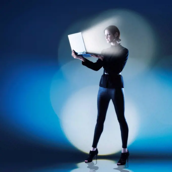 Young woman using laptop with bright light