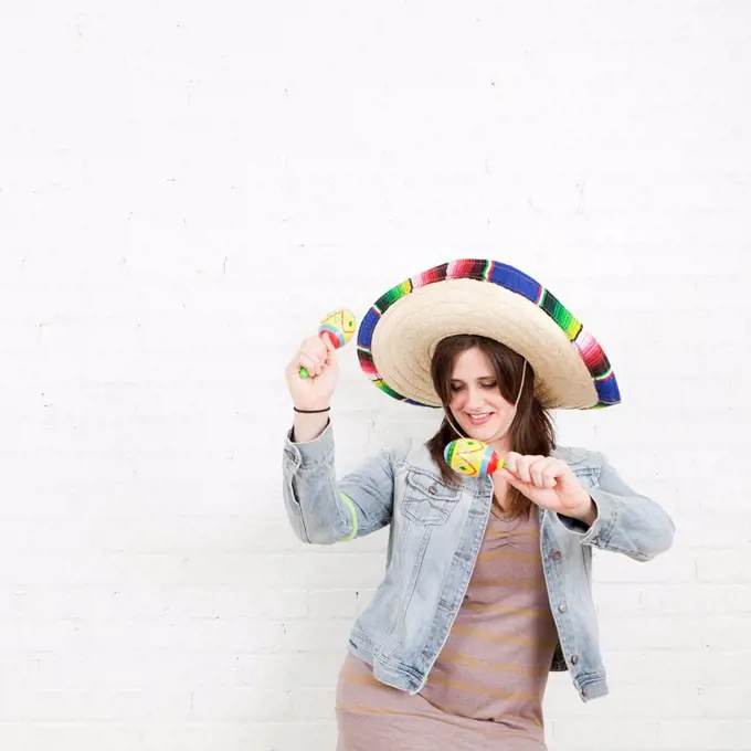 Studio Shot of young woman dancing in sombrero