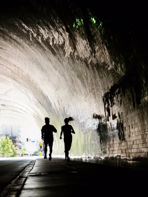 USA, California, Los Angeles, Man and woman running in tunnel