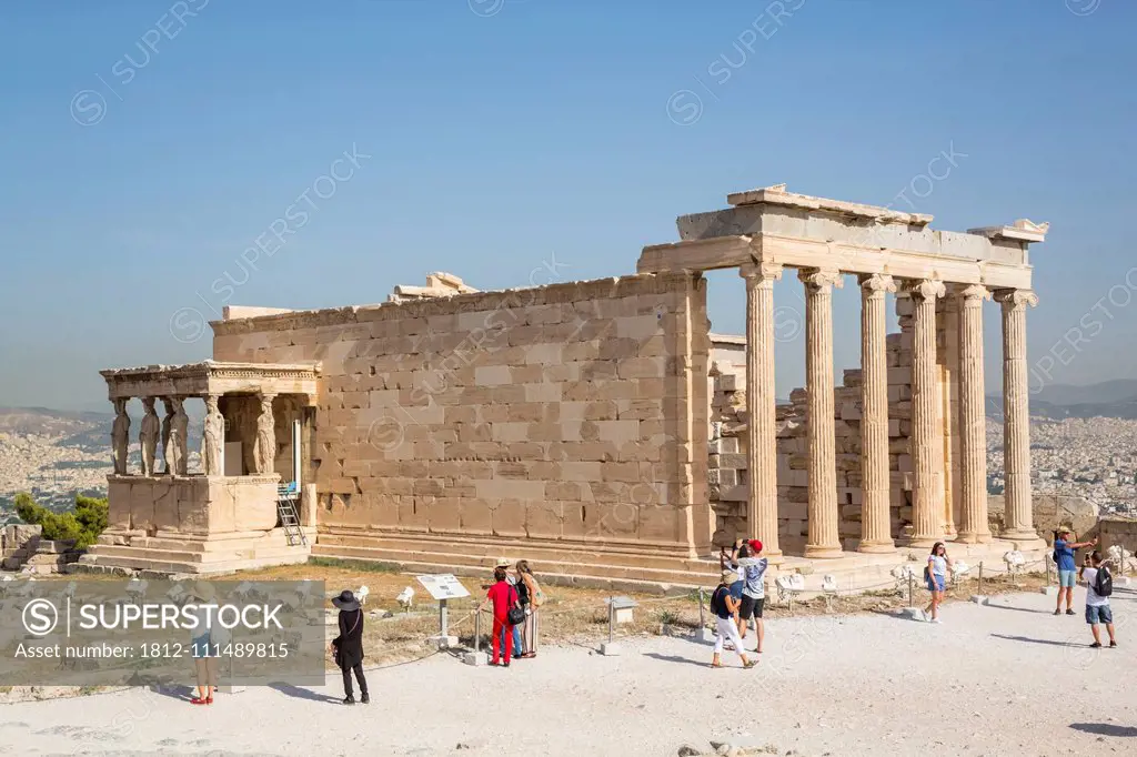 Tourists sightseeing at the Temple of Erectheion, Acropolis of Athens, archaeological site with ruins; Athens, Greece