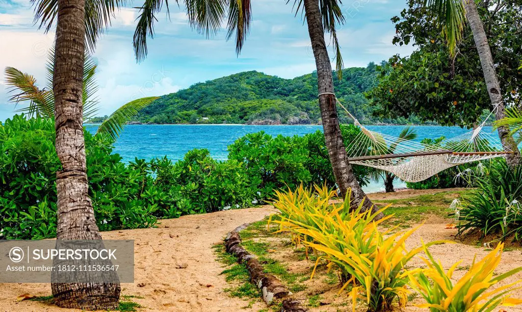 Hammock on the beach looking along the coastline of Malolo Island; Malolo Island, Fiji