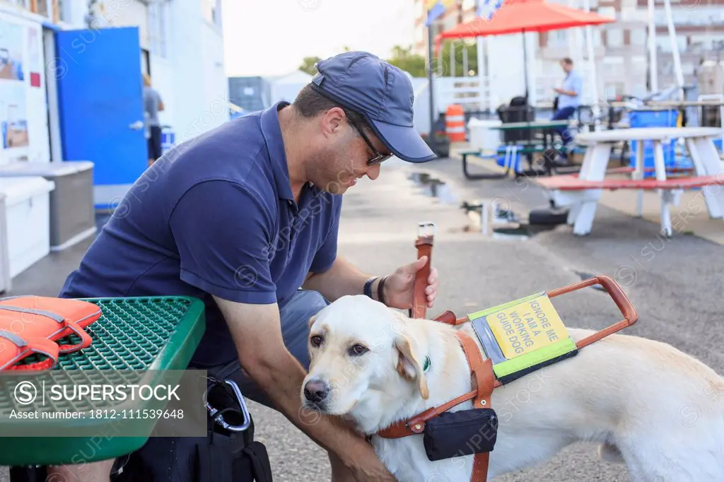 Blind man sitting with his service dog