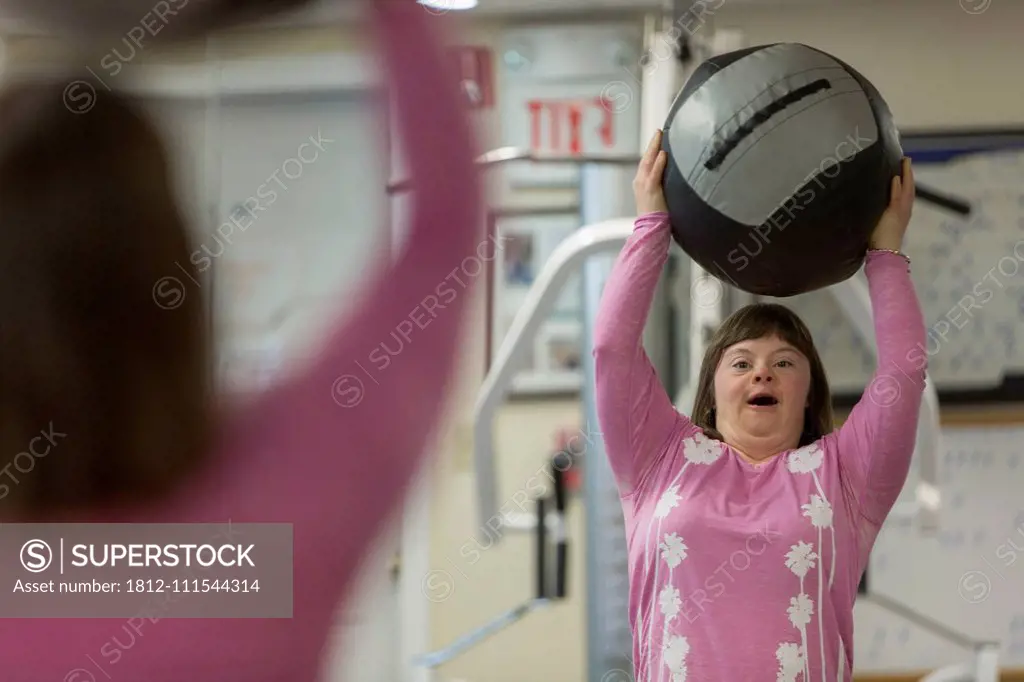 Girl with Down Syndrome working out with an exercise ball