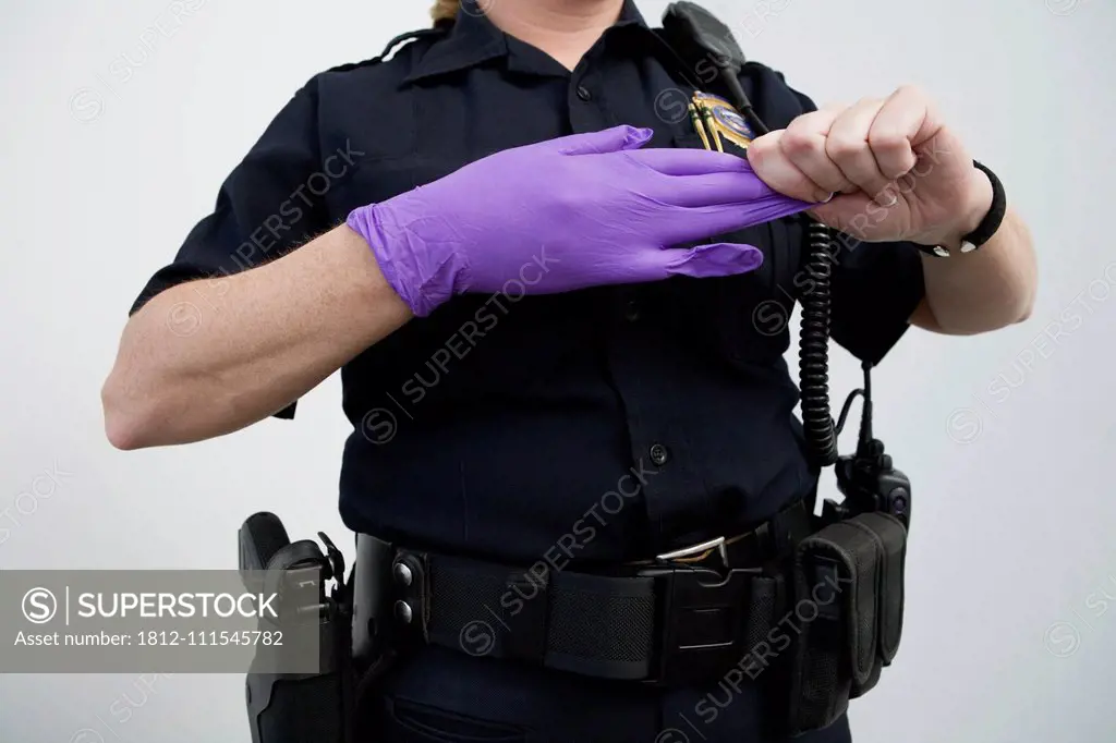 Woman police officer removing a glove.