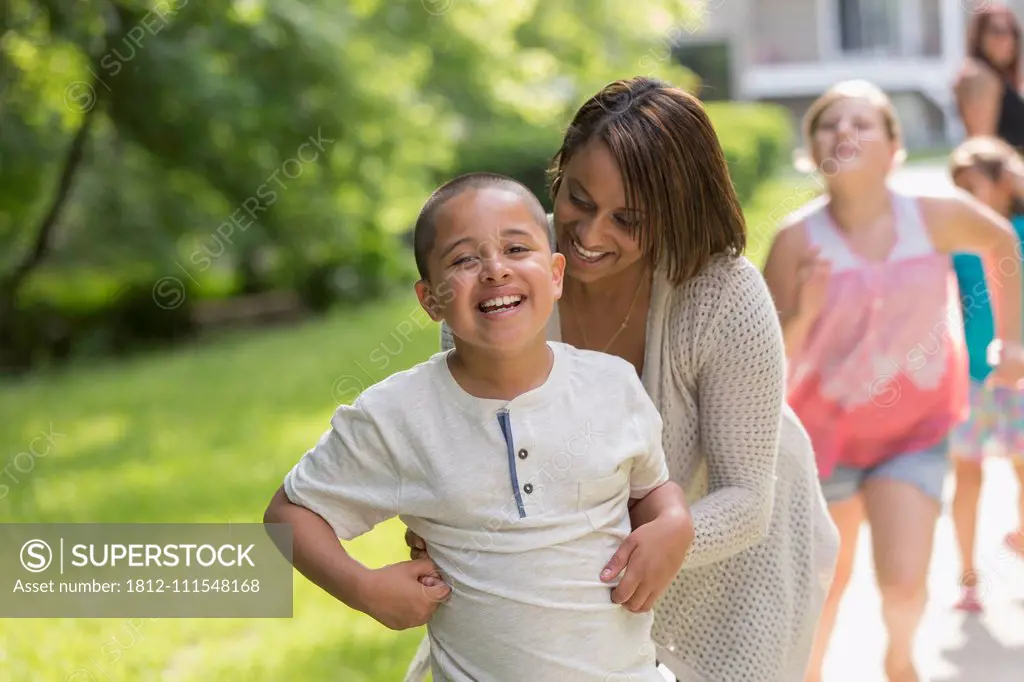 Hispanic boy with Autism playing outside with his family