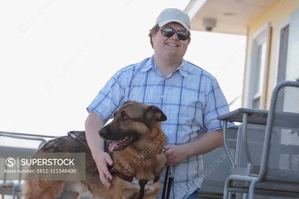 Blind man with his service dog at an outdoor cafe