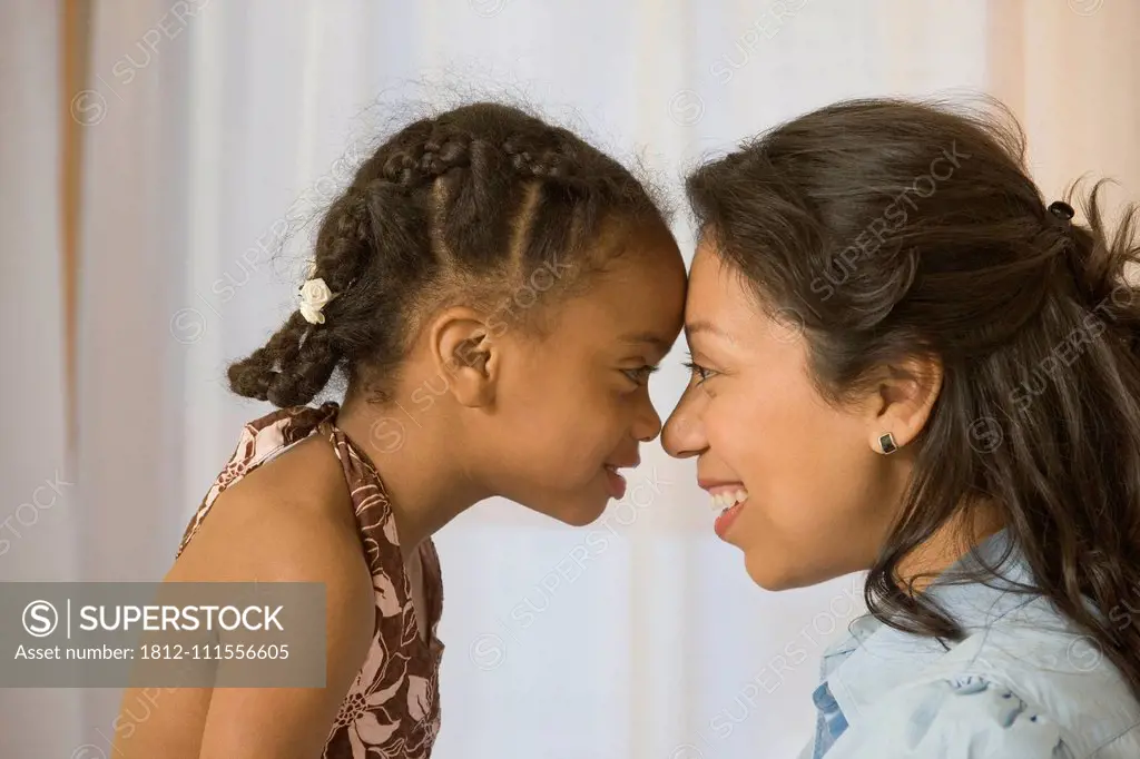 Hispanic woman rubbing noses with her daughter