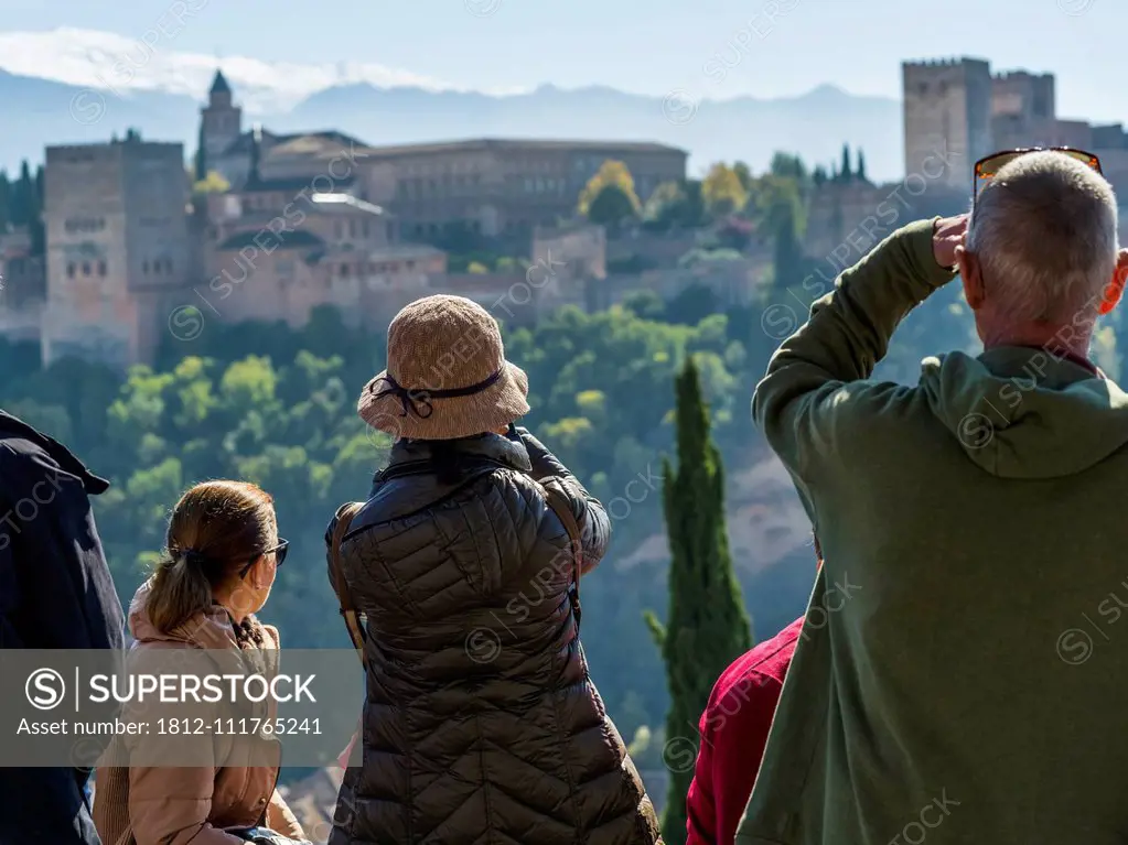 Tourists sitting with a view of the Alhambra; Granada, Andalusia, Spain
