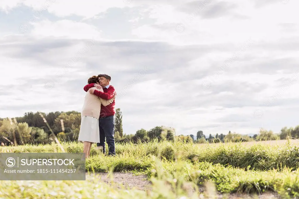 Senior couple hugging in rural landscape