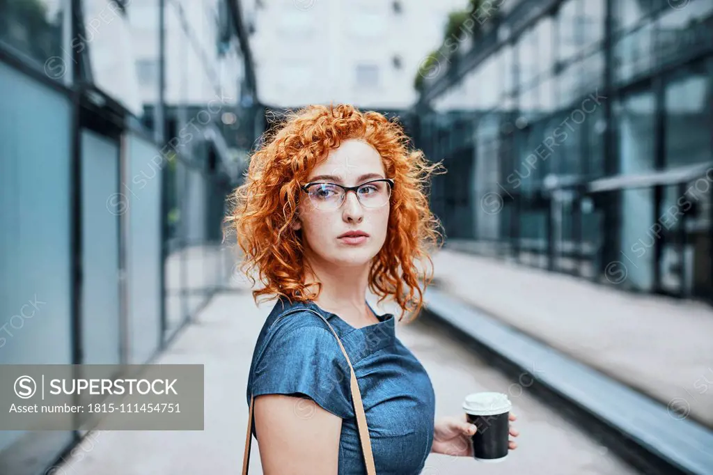 Young businesswoman holding take out coffee