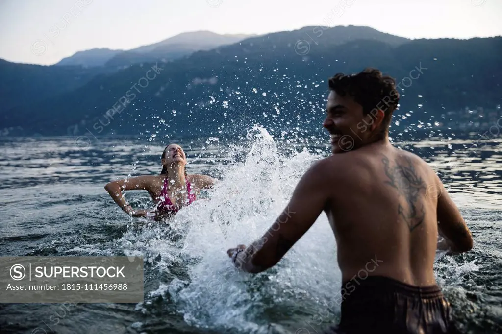 Happy young couple playing in a lake