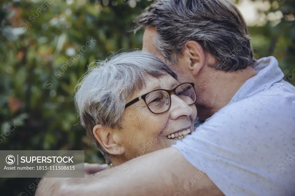 Adult son embracing his mother in the garden