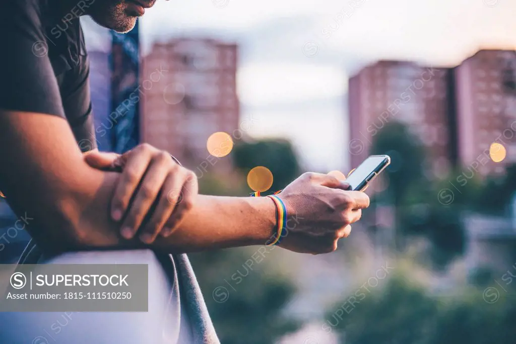 Man with pusera gay flag holding an smartphone