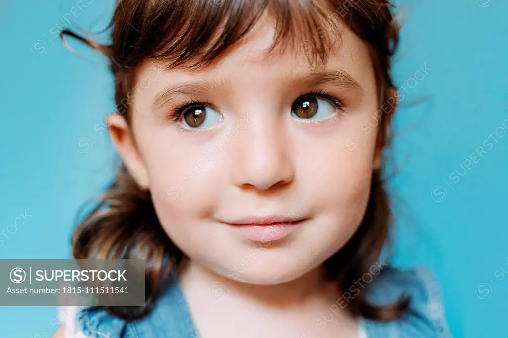 Portrait of cute little girl, blue background