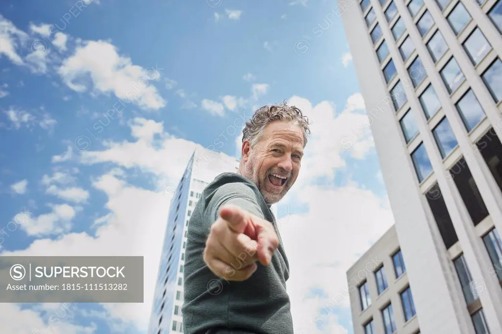 Portrait of mature man in the city screaming and pointing his finger